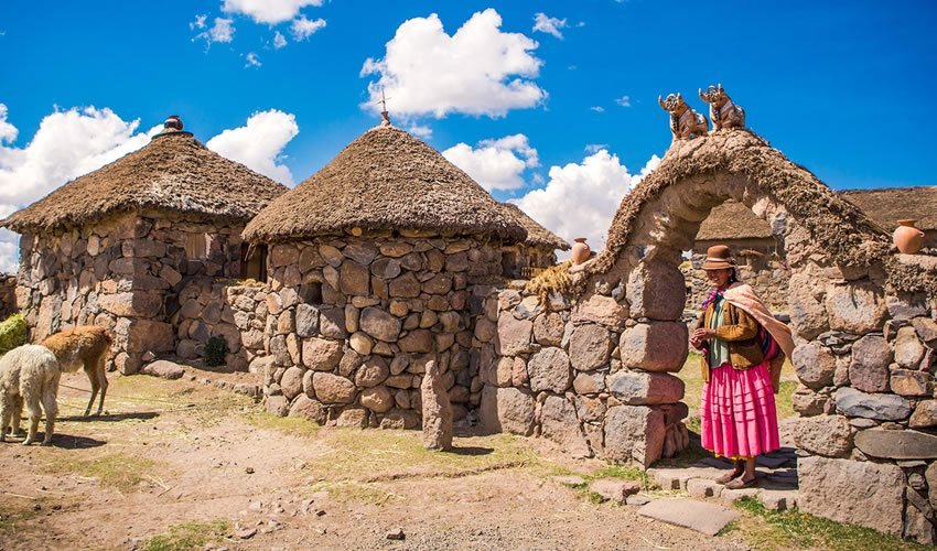 Chullpas antiguas de piedra y balsa de totora navegando en Puno